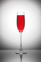 Red wine in а glass on grey background.