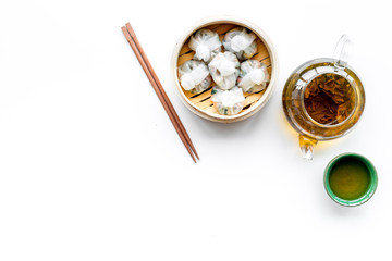 Dim sums with sticks and herbal tea in Chinese restaurant on white background top view mockup