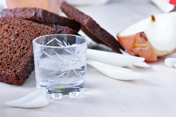 A glass of vodka and appetizer - onion and black bread