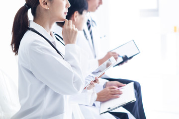 白衣の医者たちは三人で横に並び前を見つめている