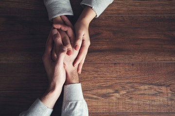 couple hand on wooden table