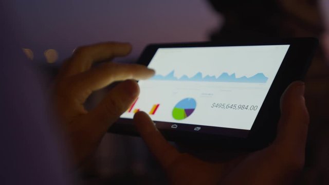 Businessman working on mobile platform outdoors managing a project Application using graphic charts looking at the data pies and vectors graphics