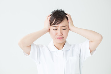 白衣を着て悩む女性アップ