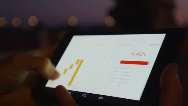 Businessman working on mobile platform outdoors managing a project Application using graphic charts looking at the data pies and vectors graphics