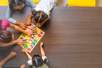 Kids and teacher playing on table