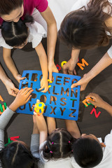 Asian teacher play Alphabet puzzle with students..