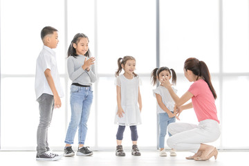 Naklejka premium Asian teacher play girls and boy some acting.