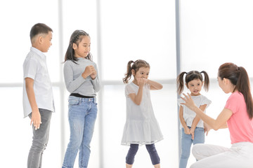 Asian teacher play girls and boy some acting.