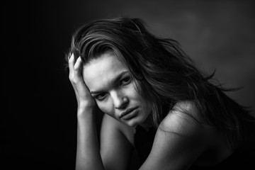 Dramatic black and white portrait of a beautiful girl on a dark background