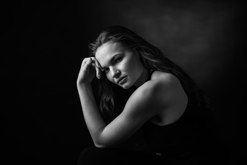 Dramatic black and white portrait of a beautiful girl on a dark background