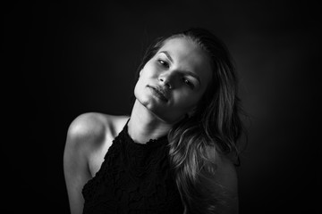 Obraz premium Dramatic black and white portrait of a beautiful girl on a dark background