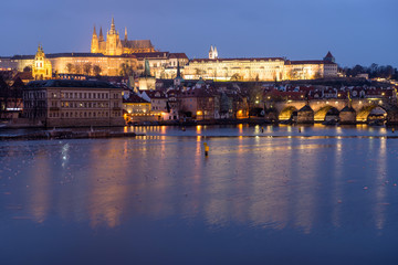 Prague Castle and Charles Bridge at sunset with reflection on Vltava river, Czech republic