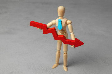 Wooden man in the tie holds the red arrow down