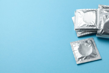 Condoms in pack on blue background. Copy space for text.