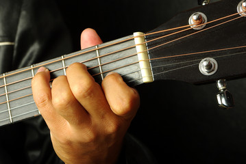 Guitarist plays the guitar. Close-up