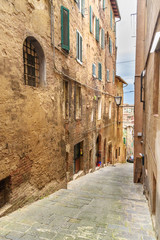 Fototapeta na wymiar Medieval narrow street Vicolo Sambuco in Siena, Tuscany, Italy.