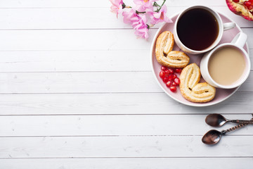 Valentine's day Breakfast concept. Cup of coffee and a cookies hearts on a white table two persons. copy space, flat lay.