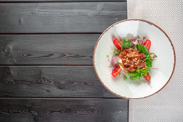 Closeup of a fresh green salad with sliced seared tenderloin steak