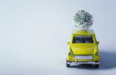 Miniature green car carry the christmas tree on is top. Shallow dof