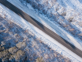 Empty winter road with snow covered trees. Aerial photo