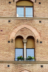 Arch window on medieval brick building. Siena. Italy