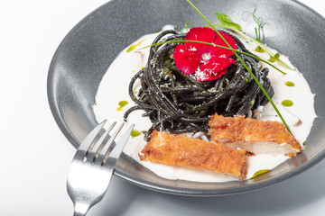 Fresh black tagliolini pasta with chicken in herbs