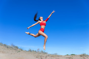 Obraz na płótnie Canvas happy young woman jumping on the beach