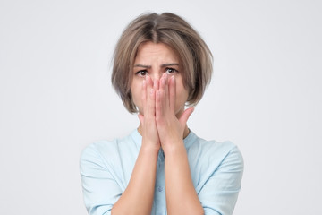 Portrait of worried scared woman in blue shirt looking at camera. She is afraid to stay alone. Lost...
