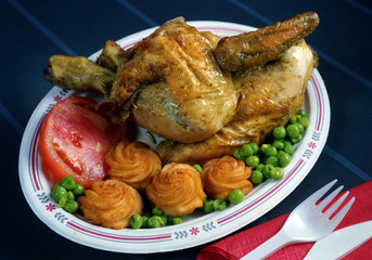 Plato combinado con medio pollo a la barbacoa, guisantes pure de patata y tomate.