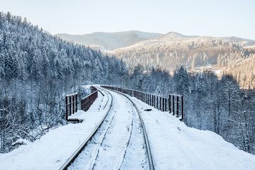 railway in snow on the railway bridge in the mountains