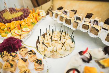 Delicious sweets on wedding candy buffet with desserts, cupcakes