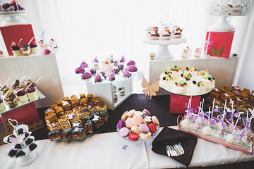 Delicious and tasty dessert table with cupcakes shots at reception closeup