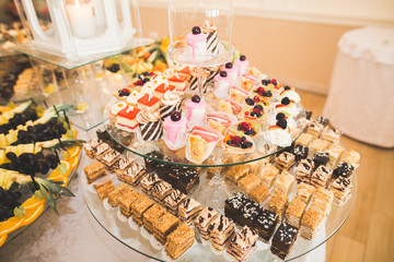 Delicious and tasty dessert table with cupcakes shots at reception closeup