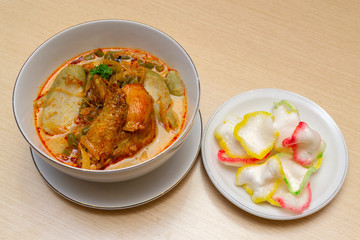 Indonesian or Malay food ketupat sayur or lontong sayur, rice cake with chicken curry on a bowl close up