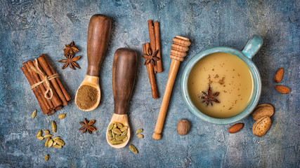Top view on traditional indian drink masala chai tea with milk and mix of spices