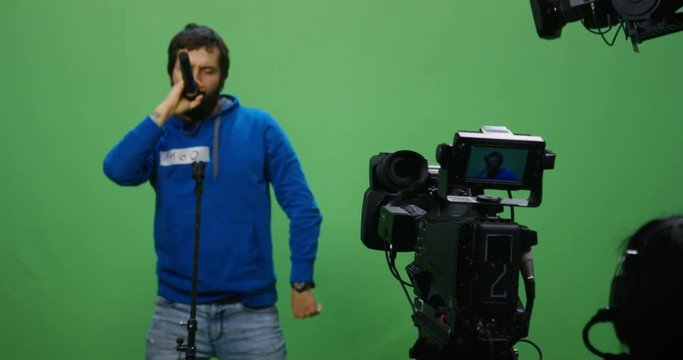 Slow motion shot of a cameraman recording a man singing at an audition