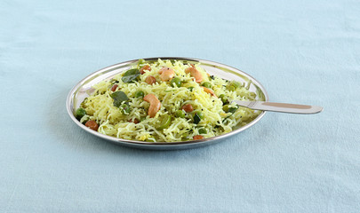 Rice noodles, a healthy and spicy south Indian vegetarian steam-cooked food, on a steel plate with spoon.