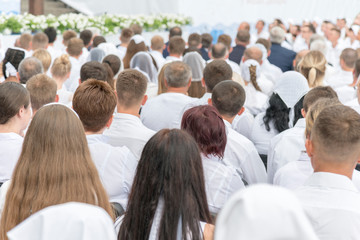 Men and women in white clothes prepare to receive water baptism.