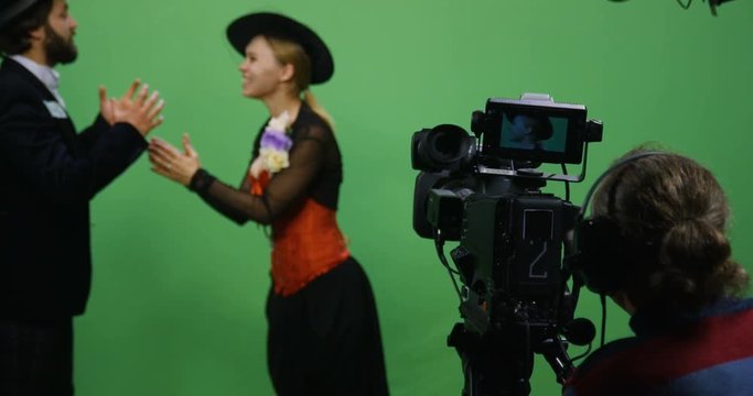 Slow motion shot of a cameraman recording an actor and an actress performing a romantic scene