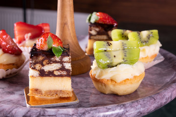 Delicious decorated sweets on marble table, cocktails party catering.