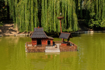Wooden house for water birds and turtles on a lake in city park