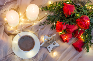 Composition: red roses with boxwood, garlands, candles, star and cup coffee (tea)