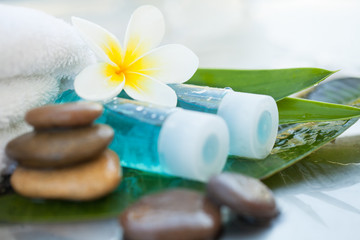 Fototapeta na wymiar Spa or wellness setting with tropical flowers and small bottle with oil. Body care and spa concept