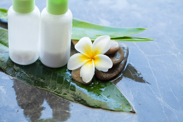 towel and cream tube for massage. Body care and spa concept with flower and stones