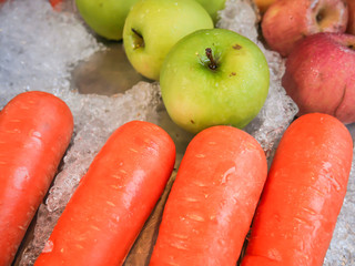 Carrots, apples, green apples on fruit ice that are sold in the market