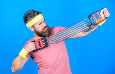 Man bearded exercising with expander. Guide used expander proper way. Sportsman stretching expander. Try stretching exercise. Athlete workout with expander. Improve your muscles with sport equipment