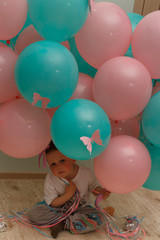Fototapeta na wymiar portrait, a sad boy with pink and blue balloons, with butterflies