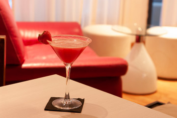 Copa de martini con coctail daikiri de fresa con borde azucarado y fresa fresca en ambiente moderno