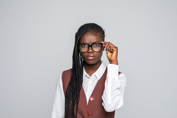 Portrait of happy young african business woman wearing glasses standing looking camera over grey background