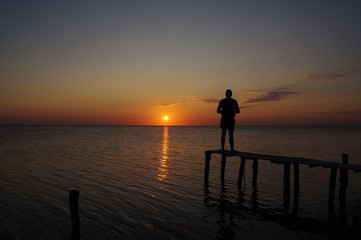 Fototapeta premium Sunset at the estuary with man